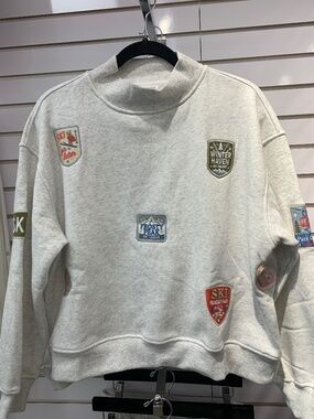 Sunday Edition gray sweatshirt with ski patches.